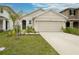 House exterior features a two-car garage and well-manicured lawn at 9228 Forge Breeze Loop Loop, Wesley Chapel, FL 33545