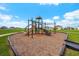 Community playground with modern equipment and wood fiber surface at 9228 Forge Breeze Loop Loop, Wesley Chapel, FL 33545