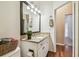 Bathroom with granite countertop, white cabinets, and view of hallway at 9232 Brindlewood Dr, Odessa, FL 33556