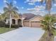 Tan house with three-car garage and palm trees at 9232 Brindlewood Dr, Odessa, FL 33556