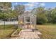 Personal greenhouse with wooden planters and brick pathway at 9232 Brindlewood Dr, Odessa, FL 33556