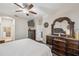 Main bedroom with ceiling fan, large dresser and ensuite bathroom at 954 Old Windsor Way, Spring Hill, FL 34609