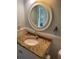 Bathroom with granite countertop, white sink, and large round mirror at 103 Old Mill Pond Rd, Palm Harbor, FL 34683