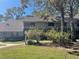 Two-story condo building with a shingled roof, surrounded by lush landscaping at 103 Old Mill Pond Rd, Palm Harbor, FL 34683