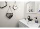 Simple bathroom with white vanity, black faucet, and heart-shaped mirrors at 1030 Charles St, Clearwater, FL 33755