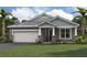 One-story home with gray siding, stone accents, and a two-car garage at 11838 Starbright Path, Venice, FL 34293