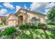 Tan one-story house with a two-car garage and manicured lawn at 122 Orange Bud Way, Plant City, FL 33563