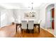 Dining room features hardwood floors, chandelier, and adjacent kitchen view at 12405 Crestridge Loop, New Port Richey, FL 34655