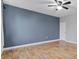 Bedroom with hardwood floors and a blue accent wall at 1264 Riserva Ln, Palm Harbor, FL 34683