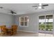 Living room with tile floors, ceiling fan, and sliding glass doors at 1264 Riserva Ln, Palm Harbor, FL 34683