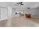 Open-concept living room with tile floors, ceiling fans, with adjacent modern kitchen and dining area at 1264 Riserva Ln, Palm Harbor, FL 34683