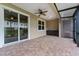 A covered patio featuring brick pavers, a ceiling fan, and a built-in cabinet for outdoor convenience at 1264 Riserva Ln, Palm Harbor, FL 34683