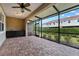 Spacious screened patio featuring brick flooring, ceiling fan, and a view of the fenced yard at 1264 Riserva Ln, Palm Harbor, FL 34683