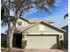 Two-story house with a neutral exterior, two-car garage, and landscaping at 1348 Impatiens Ct, Trinity, FL 34655