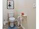 Small bathroom with toilet, floating shelf, and blue rug at 14638 Strathglass Dr, Hudson, FL 34667