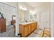 Double vanity bathroom with wood cabinets and a view of a bedroom at 14638 Strathglass Dr, Hudson, FL 34667