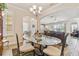 Elegant dining room features a glass-top table, chandelier, and hardwood floors at 14638 Strathglass Dr, Hudson, FL 34667