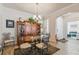 Formal dining room with glass-top table, wood hutch, and chandelier at 14638 Strathglass Dr, Hudson, FL 34667