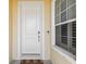 Front entry with white door and window with shutters at 14638 Strathglass Dr, Hudson, FL 34667