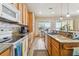 Bright kitchen with granite countertops, wood cabinets, and tile flooring at 14638 Strathglass Dr, Hudson, FL 34667