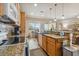 Modern kitchen featuring granite countertops, wood cabinets, and a double sink at 14638 Strathglass Dr, Hudson, FL 34667