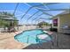 Relaxing kidney-shaped pool with screened enclosure and patio furniture at 14638 Strathglass Dr, Hudson, FL 34667