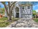 Two-story house with gray siding, large trees, and a driveway at 1542 Mccrea Dr, Lutz, FL 33549