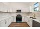 Modern kitchen with white cabinets, quartz countertops, and stainless steel appliances at 15958 Adobe Dr, Hudson, FL 34667