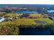 Aerial view of a spacious lot with a home, barn, and lake in the background at 18029 Lake Reflections Blvd, Lutz, FL 33558