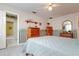 Another bedroom with wood dresser and light-toned bedding at 18029 Lake Reflections Blvd, Lutz, FL 33558