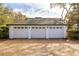 Three-car garage with white doors and a brick paved driveway at 18029 Lake Reflections Blvd, Lutz, FL 33558