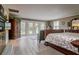 Main bedroom with hardwood floors, French doors, and views of the backyard at 18029 Lake Reflections Blvd, Lutz, FL 33558