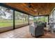 Relaxing screened porch with wicker furniture overlooks a scenic pasture at 18029 Lake Reflections Blvd, Lutz, FL 33558