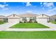 Three-unit building exterior, featuring attached garages and a grassy lawn at 18058 Turning Leaf Cir, Land O Lakes, FL 34638