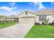 Exterior view of a light beige single-Gathering home with a two-car garage at 18058 Turning Leaf Cir, Land O Lakes, FL 34638