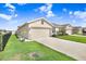 Exterior view of a light beige single-Gathering home with a two-car garage at 18058 Turning Leaf Cir, Land O Lakes, FL 34638