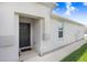 Side view of a house entrance with dark door and walkway at 18058 Turning Leaf Cir, Land O Lakes, FL 34638