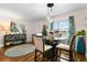 Bright dining room with glass table and four chairs, features hardwood floors and large window at 1809 Wolf Laurel Dr, Sun City Center, FL 33573