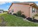 Side view of tan house with well-maintained landscaping and lawn at 1809 Wolf Laurel Dr, Sun City Center, FL 33573