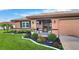 Front view of tan house with landscaping, covered entry and attached garage at 1809 Wolf Laurel Dr, Sun City Center, FL 33573