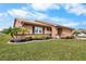 Front view of tan house with landscaping, driveway and attached garage at 1809 Wolf Laurel Dr, Sun City Center, FL 33573