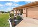 House exterior showcasing a covered entryway, landscaping, and attached garage at 1809 Wolf Laurel Dr, Sun City Center, FL 33573