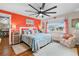 Coastal-themed bedroom with coral-colored wall, comfortable seating, and large window at 1809 Wolf Laurel Dr, Sun City Center, FL 33573