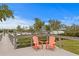 Relaxing deck overlooking the marina with two orange Adirondack chairs at 19915 Gulf Blvd # 303, Indian Shores, FL 33785