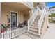 Townhouse entry with stairs, a small patio, and a welcoming sign at 19915 Gulf Blvd # 303, Indian Shores, FL 33785