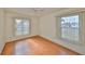 Bedroom with wood flooring and two large windows at 243 Linger Ln, Sun City Center, FL 33573