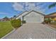 Front view of a charming house with a brick driveway at 243 Linger Ln, Sun City Center, FL 33573