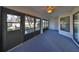 Enclosed porch with grey carpeting and access to backyard at 243 Linger Ln, Sun City Center, FL 33573