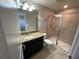 Bathroom with shower, granite countertop, and dark cabinets at 28489 Tranquil Lake Cir, Wesley Chapel, FL 33543