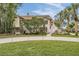 Landscaped grounds and house exterior with palm trees and walkway at 314 Shore E Dr, Oldsmar, FL 34677